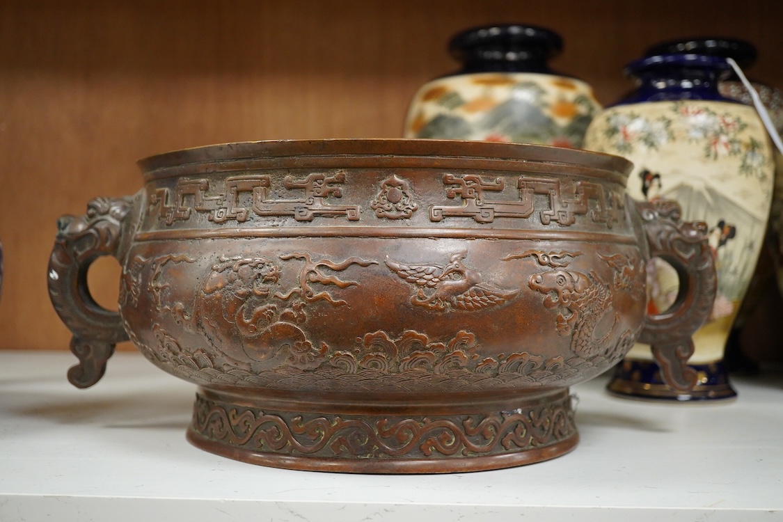 A large Chinese archaistic bronze censer, decorated in relief, with twin handles, 38cm in diameter